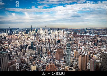 Admirez l'étalement impressionnant des gratte-ciels de Manhattan depuis un point de vue audacieux en contrebas. Des géants imposants traversent les nuages, offrant une vue unique. Banque D'Images