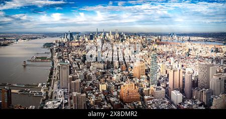 Admirez l'étalement impressionnant des gratte-ciels de Manhattan depuis un point de vue audacieux en contrebas. Des géants imposants traversent les nuages, offrant une vue unique. Banque D'Images