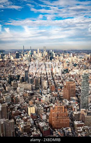 Admirez l'étalement impressionnant des gratte-ciels de Manhattan depuis un point de vue audacieux en contrebas. Des géants imposants traversent les nuages, offrant une vue unique. Banque D'Images