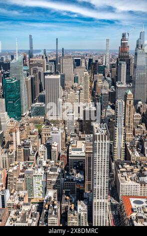 Admirez l'étalement impressionnant des gratte-ciels de Manhattan depuis un point de vue audacieux en contrebas. Des géants imposants traversent les nuages, offrant une vue unique. Banque D'Images