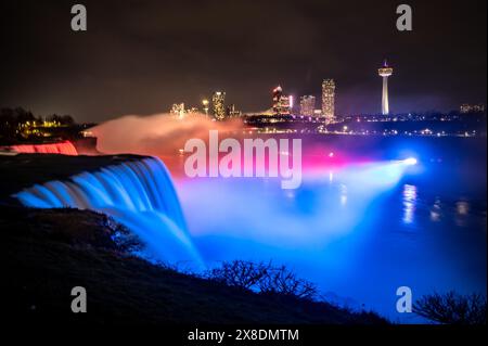 La cascade illuminée de Niagara sous un ciel nuageux ! L'eau soyeuse coule sur fond de lumières canadiennes. Parfait pour le voyage et le photog longue exposition Banque D'Images