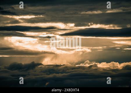 Coucher de soleil doré à travers des nuages dramatiques Banque D'Images