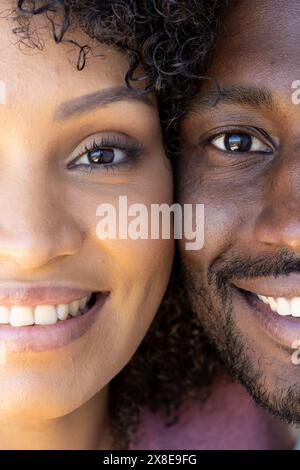 Un couple diversifié à la maison, souriant étroitement ensemble Banque D'Images