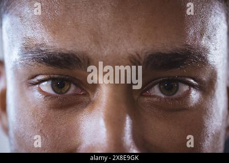 Au gymnase, homme biracial avec une apparence forte et en forme se concentrant intensément. Gros plan avec une expression déterminée et un dévouement à la forme physique, montrant des salutations Banque D'Images
