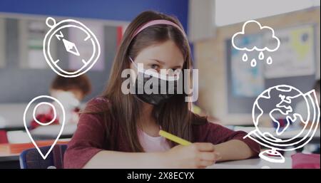 À l'école, étudiante caucasienne portant un masque assis à un bureau Banque D'Images