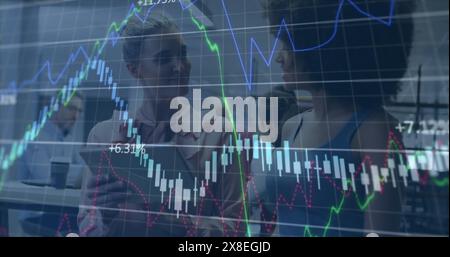 Image de plusieurs graphiques et de diverses collègues féminines discutant sur tablette au bureau Banque D'Images