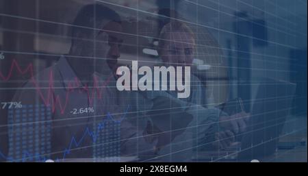 Image de plusieurs graphiques et de divers collègues discutant sur un ordinateur portable au bureau Banque D'Images