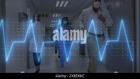 Image d'un moniteur de fréquence cardiaque sur divers médecins et travailleurs de la santé qui courent dans le couloir de l'hôpital Banque D'Images