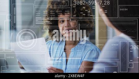 Image de graphiques, de cercles et de barres de chargement, de collègues féminines diverses discutant des rapports au bureau Banque D'Images