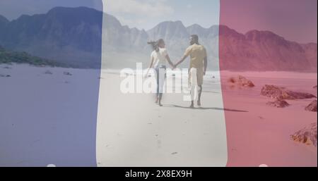 Image du drapeau de la france et des feux d'artifice sur couple biracial heureux marchant à la plage Banque D'Images