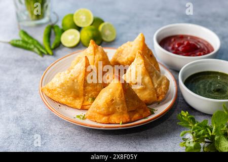 Sélection Focus Samosa, pâtisserie aux pommes de terre épicées, croustillante, salée et populaire en-cas indien servi avec des thés chutney à la tomate et à la menthe. Banque D'Images
