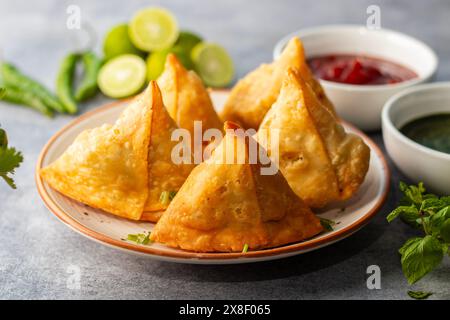Sélection Focus Samosa, pâtisserie aux pommes de terre épicées, croustillante, salée et populaire en-cas indien servi avec des thés chutney à la tomate et à la menthe. Banque D'Images