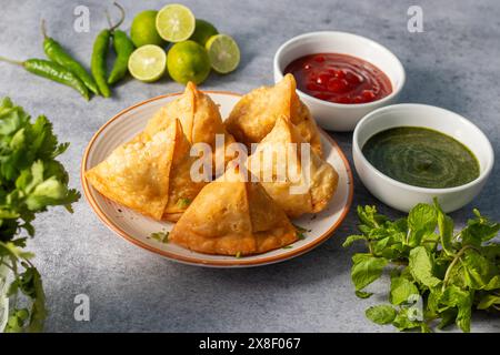 Sélection Focus Samosa, pâtisserie aux pommes de terre épicées, croustillante, salée et populaire en-cas indien servi avec des thés chutney à la tomate et à la menthe. Banque D'Images