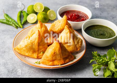 Sélection Focus Samosa, pâtisserie aux pommes de terre épicées, croustillante, salée et populaire en-cas indien servi avec des thés chutney à la tomate et à la menthe. Banque D'Images