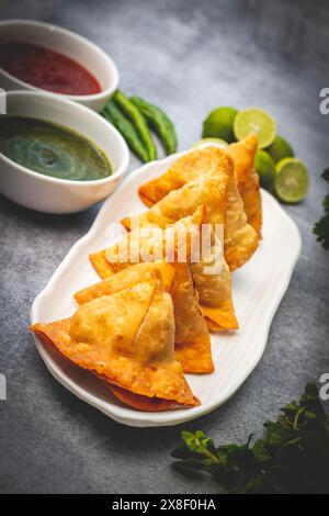 Sélection Focus Samosa, pâtisserie aux pommes de terre épicées, croustillante, salée et populaire en-cas indien servi avec des thés chutney à la tomate et à la menthe. Banque D'Images