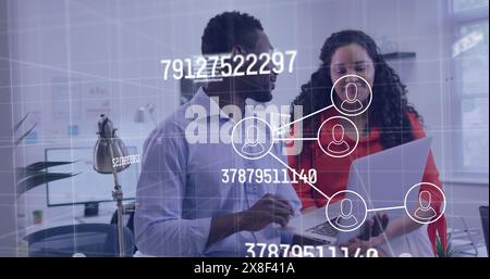 Image d'icônes connectées, de chiffres et de lettres changeant, de collègues discutant des rapports Banque D'Images