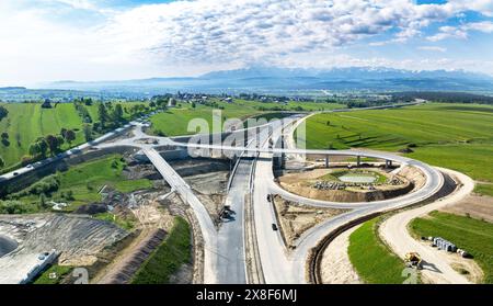 Nouveau fragment d'autoroute en construction sur la route de Zakopianka, Pologne, dégageant la ville de Nowy Targ. Rampes d'entrée et de sortie, rond-point. État en mai Banque D'Images