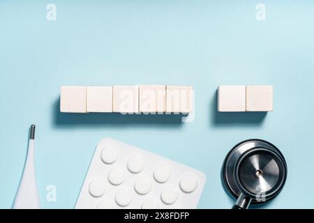 Articles médicaux et blocs en bois sur fond bleu clair Banque D'Images