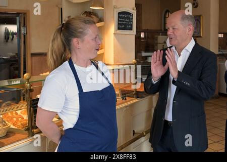 Potsdam, Allemagne. 25 mai 2024. Le chancelier fédéral Olaf Scholz en conversation avec un employé de boulangerie à Krongut Bornstedt. Scholz a répondu aux questions des participants à une discussion de circonscription au Krongut. Crédit : Michael Bahlo/dpa/Alamy Live News Banque D'Images