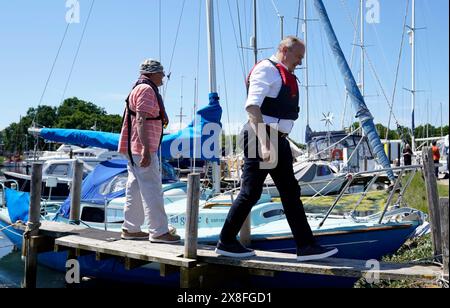 Le leader libéral démocrate Sir Ed Davey débarque d'un bateau après avoir fait un voyage autour de Birdham Pool Marina près de Chichester, pour annoncer les plans de son parti d'abolir OFWAT et d'introduire un nouveau régulateur d'eau pour lutter contre la crise des eaux usées, alors qu'il est sur la piste de la campagne électorale générale. Date de la photo : samedi 25 mai 2024. Banque D'Images