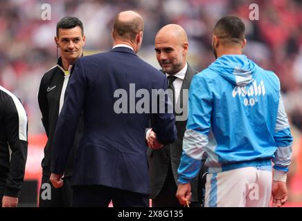 Le Prince de Galles serre la main au manager de Manchester City, Pep Guardiola (à droite), avant la finale de la FA Cup de l’Emirates au stade de Wembley, à Londres. Date de la photo : samedi 25 mai 2024. Banque D'Images