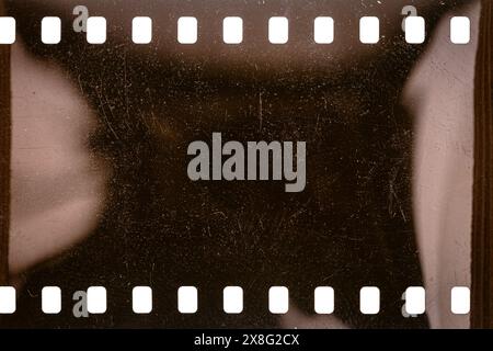 Texture ou surface poussiéreuse et rugueuse du film 35 mm.Film perforé rayé isolé sur fond blanc. Banque D'Images