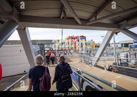 Les passagers descendent la bretelle pour prendre le Dazzle Ferry à travers le Mersey au front de mer de Liverpool, Merseyside, Royaume-Uni le 21 mai 2024 Banque D'Images