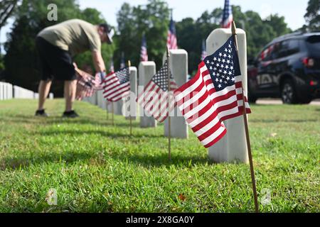 Raleigh, Caroline du Nord, États-Unis, 25 mai 2024; les bénévoles placent des drapeaux sur les pierres tombales de 6 000 au cimetière national de Raleigh avant le jour férié du Memorial Day. L'événement annuel, organisé par la Raleigh American Legion, honore les hommes et les femmes américains qui ont servi dans l'armée américaine en temps de paix et de guerre. Le cimetière national de Raleigh comprend les tombes des militaires de la guerre civile aux guerres d'Irak et d'Afghanistan. Credit d Guest Smith / Alamy Live News Banque D'Images