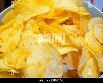 Gourmandises. Délicieuses chips de pommes de terre dans un éclairage lumineux, idéales pour les présentations culinaires. Banque D'Images