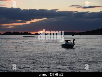 Photographie d'un bateau de pêche au coucher du soleil dans le port de Poole Banque D'Images
