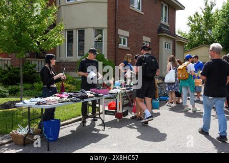 Ottawa, Canada - le 25 mai 2024 : une foule énorme de gens recherche des offres lors de la vente annuelle de garage de quartier Glebe qui a lieu à plusieurs pâtés de maisons dans le quartier Glebe d'Ottawa, Ontario. Banque D'Images