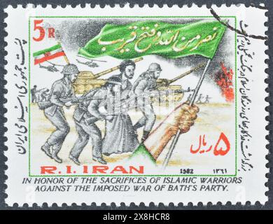 Timbre-poste oblitéré imprimé par l'Iran, qui montre la commémoration des victimes de la guerre contre l'Irak, vers 1982. Banque D'Images