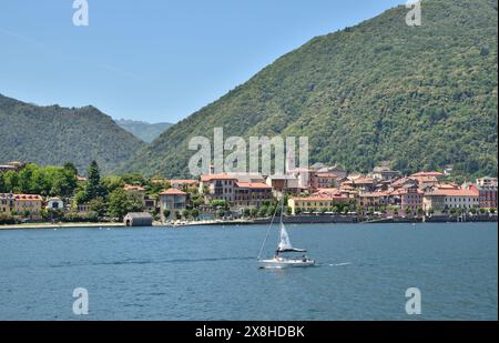 Yacht solitaire naviguant sur les eaux bleues du lac majeur, Italie. Banque D'Images