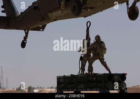 14 mai 2024 - Jordanie - des soldats américains, affectés à la Task Force Hurricane et à la Task Force Sentinel, sécurisent un nacelle de système de lanceurs multiples guidé à un Blackhawk UH-60A lors d'un entraînement en soutien à Eager Lion 2024 à la base aérienne Muwaffaq Salti, Jordanie, le 14 mai 2024. Eager Lion 2024 est un exercice multilatéral, avec 33 pays participants, organisé par le Royaume hachémite de Jordanie, conçu pour échanger des compétences militaires et améliorer l'interopérabilité entre les pays partenaires, et considéré comme la pierre angulaire d'une relation militaire plus large des États-Unis avec les forces armées jordaniennes. Jordan est l'un des États-Unis C Banque D'Images