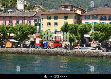 Le bord du lac à Ascona, Suisse. Un ancien bus London transport Routemaster faisant la publicité des boissons Fevertree se trouve sur la promenade. Banque D'Images