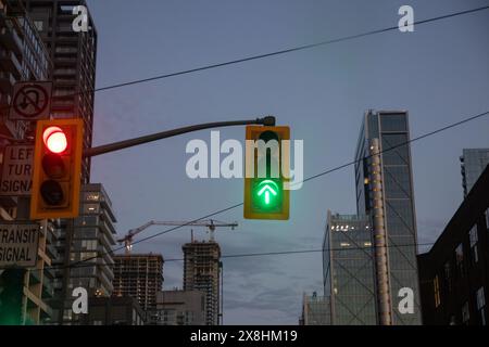 Paysage urbain en soirée - feux stop rouges - gratte-ciel et grue de construction contre le ciel crépusculaire. Prise à Toronto, Canada. Banque D'Images