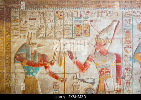 Un relief à l'intérieur du temple de Seti I à Abydos, en Égypte, montrant le pharaon Seti I portant la double couronne (pschent) et le Dieu de l'au-delà Anubis Banque D'Images