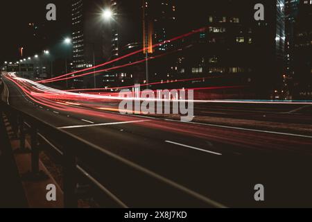 Pistes légères des voitures qui traversent l'autoroute Banque D'Images