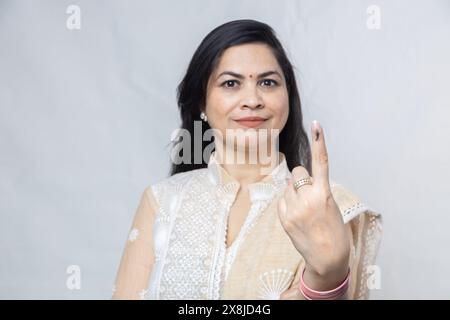 Election en inde. Portrait d'une femme portant le hijab montre doigt marqué avec de l'encre après avoir voté debout isolé sur fond blanc, Polling Boo Banque D'Images