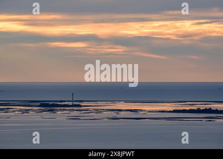 Phare et Punta de la Banya dans un lever de soleil d'hiver, vu de la Ràpita (Tarragone, Catalogne, Espagne) ESP : Faro y punta de la Banya al amanecer Banque D'Images