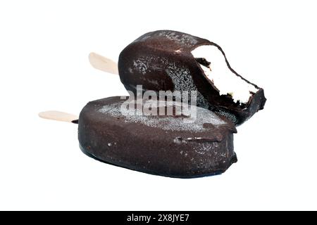 Deux glaces sur bâtonnets dans le glaçage au chocolat. L'un est mordu. Banque D'Images