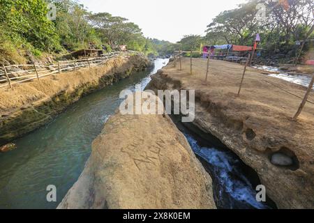 Dolores, Philippines. 25 mai 2024 : les Philippins affluent vers des ruisseaux qui ne se sont pas asséchés pour échapper à la chaleur étouffante des villes. À Calabarzon, certains trouvent refuge aux chutes de Paeng, une nouvelle destination créée par le typhon Paeng(2022). Coulant du mont Banahaw, une montagne sacrée sujette aux glissements de terrain, à l'érosion et aux crues éclair destructrices, le lit de la rivière Lagnas s'est affaissé pour former ces cascades très appréciées car l'archipel et l'Asie du Sud-est souffrent d'une vague de chaleur sévère et de sécheresse due à El Nino qui se terminera par la dépression tropicale Aghon, première tempête à frapper le pays cette année. Crédit : Kevin Izorce/Alamy Live News Banque D'Images