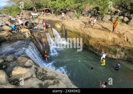 Dolores, Philippines. 25 mai 2024 : les Philippins affluent vers des ruisseaux qui ne se sont pas asséchés pour échapper à la chaleur étouffante des villes. À Calabarzon, certains trouvent refuge aux chutes de Paeng, une nouvelle destination créée par le typhon Paeng(2022). Coulant du mont Banahaw, une montagne sacrée sujette aux glissements de terrain, à l'érosion et aux crues éclair destructrices, le lit de la rivière Lagnas s'est affaissé pour former ces cascades très appréciées car l'archipel et l'Asie du Sud-est souffrent d'une vague de chaleur sévère et de sécheresse due à El Nino qui se terminera par la dépression tropicale Aghon, première tempête à frapper le pays cette année. Crédit : Kevin Izorce/Alamy Live News Banque D'Images