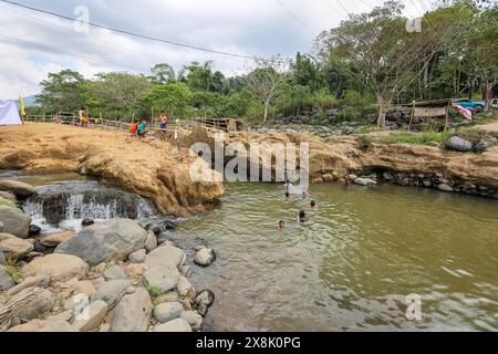 Dolores, Philippines. 25 mai 2024 : les Philippins affluent vers des ruisseaux qui ne se sont pas asséchés pour échapper à la chaleur étouffante des villes. À Calabarzon, certains trouvent refuge aux chutes de Paeng, une nouvelle destination créée par le typhon Paeng(2022). Coulant du mont Banahaw, une montagne sacrée sujette aux glissements de terrain, à l'érosion et aux crues éclair destructrices, le lit de la rivière Lagnas s'est affaissé pour former ces cascades très appréciées car l'archipel et l'Asie du Sud-est souffrent d'une vague de chaleur sévère et de sécheresse due à El Nino qui se terminera par la dépression tropicale Aghon, première tempête à frapper le pays cette année. Crédit : Kevin Izorce/Alamy Live News Banque D'Images