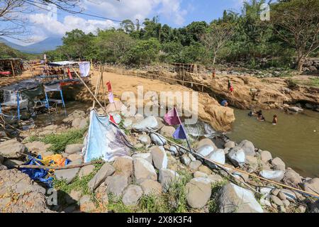 Dolores, Philippines. 25 mai 2024 : les Philippins affluent vers des ruisseaux qui ne se sont pas asséchés pour échapper à la chaleur étouffante des villes. À Calabarzon, certains trouvent refuge aux chutes de Paeng, une nouvelle destination créée par le typhon Paeng(2022). Coulant du mont Banahaw, une montagne sacrée sujette aux glissements de terrain, à l'érosion et aux crues éclair destructrices, le lit de la rivière Lagnas s'est affaissé pour former ces cascades très appréciées car l'archipel et l'Asie du Sud-est souffrent d'une vague de chaleur sévère et de sécheresse due à El Nino qui se terminera par la dépression tropicale Aghon, première tempête à frapper le pays cette année. Crédit : Kevin Izorce/Alamy Live News Banque D'Images