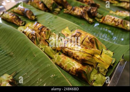 Riz collant doux grillé thaïlandais avec garniture enveloppé dans une feuille de banane appelé Khao Niao Ping Banque D'Images