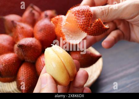 Gros plan sur les lobes de fruits de salak ou de fruit de peau de serpent avec grappes de fruits floues en toile de fond Banque D'Images