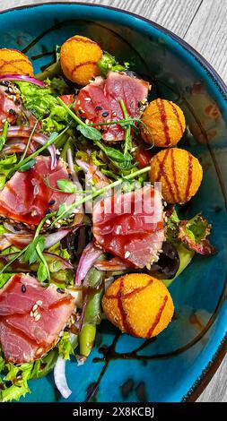 Salade avec boulettes de thon et de fromage nappées de sauce soja. Nourriture rapide et saine. Banque D'Images