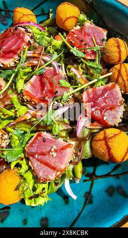 Salade avec boulettes de thon et de fromage nappées de sauce soja. Nourriture rapide et saine. Banque D'Images