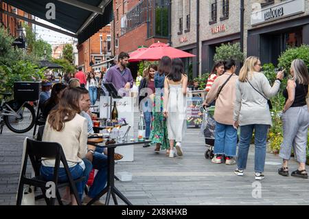 Les gens apprécient le temps libre dans un marché extérieur animé avec des magasins et des sièges en plein air. Chelsea Londres Royaume-Uni Banque D'Images